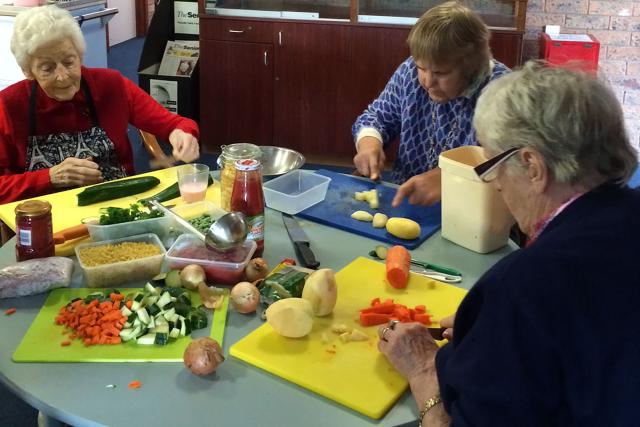 Residents chopping vegetables to help prepare dinner