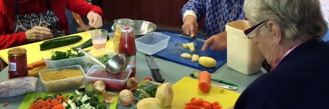 Residents chopping vegetables to help prepare dinner